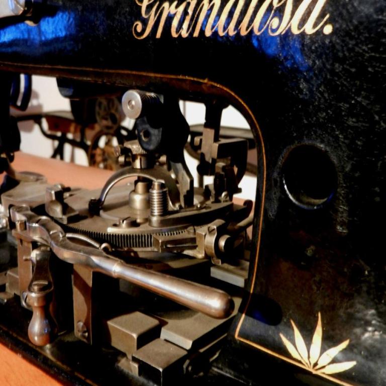 Detailaufnahme eines antiken, schwarzen Nähmaschine mit dem eingeprägten Namen Grandiosa.