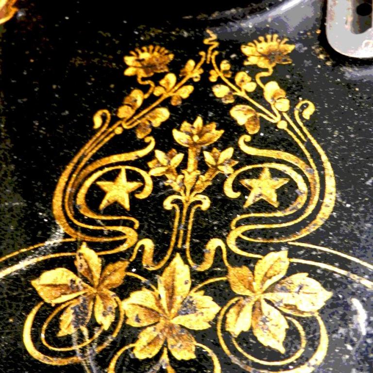 Goldverzierungen mit floralen Motiven und Sternen auf einem dunklen, glänzenden Hintergrund