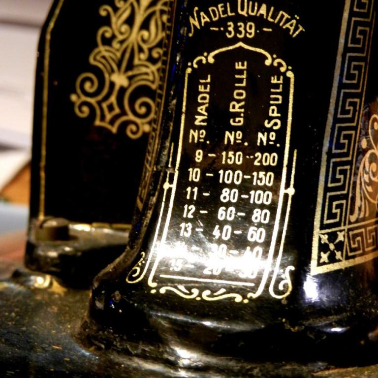 Nahaufnahme von einer alten Nähmaschine, die verschiedene Nadel- und Rollegrößen mit Qualitätsangaben anzeigt.