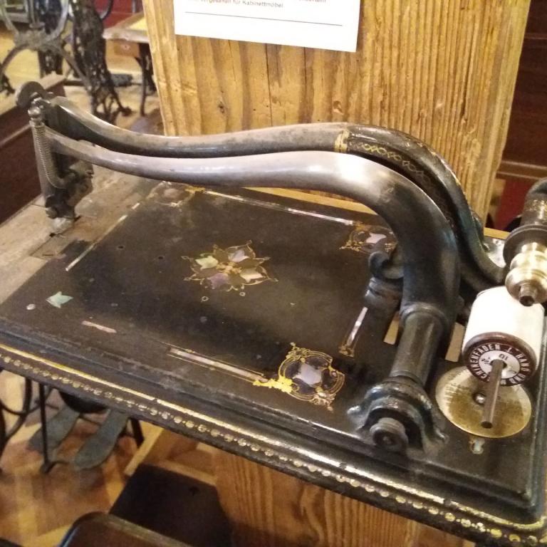 Antike, dunkle Nähmaschine mit Griff, ausgestellte Museumsausstellung.